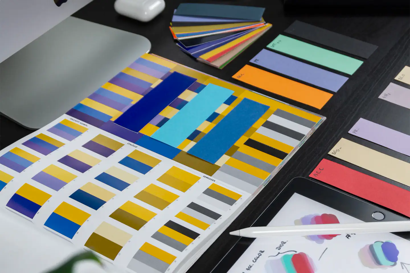 Color swatches and palette studies beside a tablet
