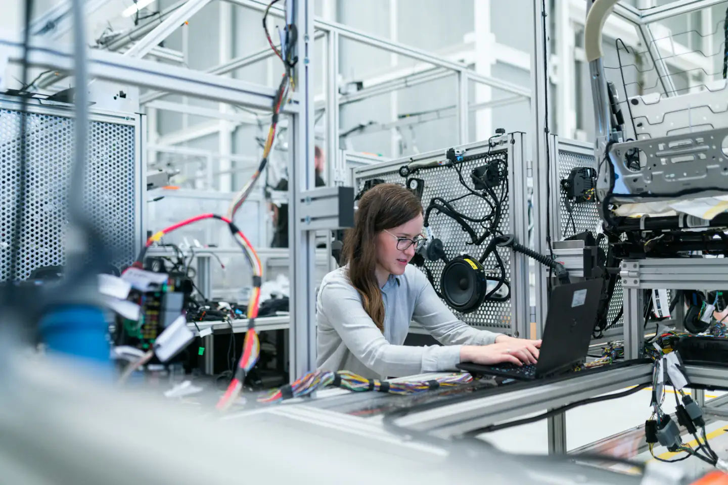 Engineer working at a laptop beside robotics equipment